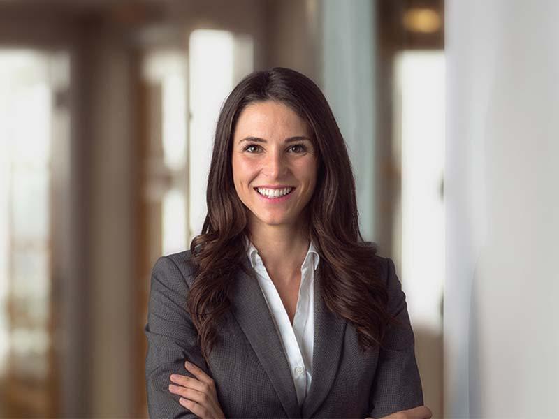 Confident businesswoman smiling with arms crossed in a professional setting